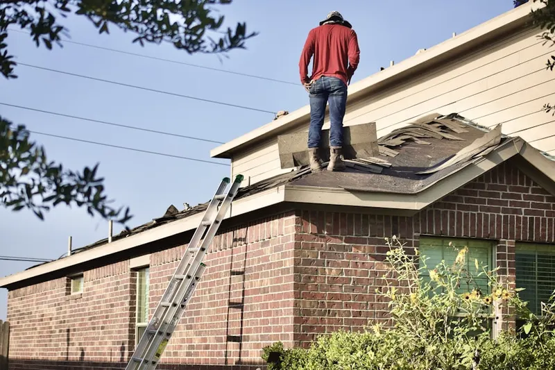 Professional roofer working on a residential roof in Cedar Land